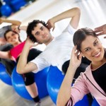 People in a gym class doing situps