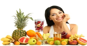 Girl with fresh fruits isolated on white